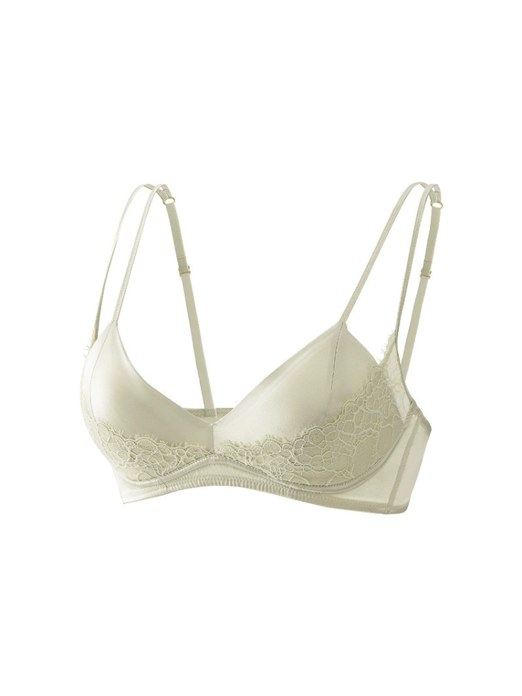 Angled view of a pale sprout green silk bra with delicate floral lace detailing, V-shaped cups, and slender double straps.