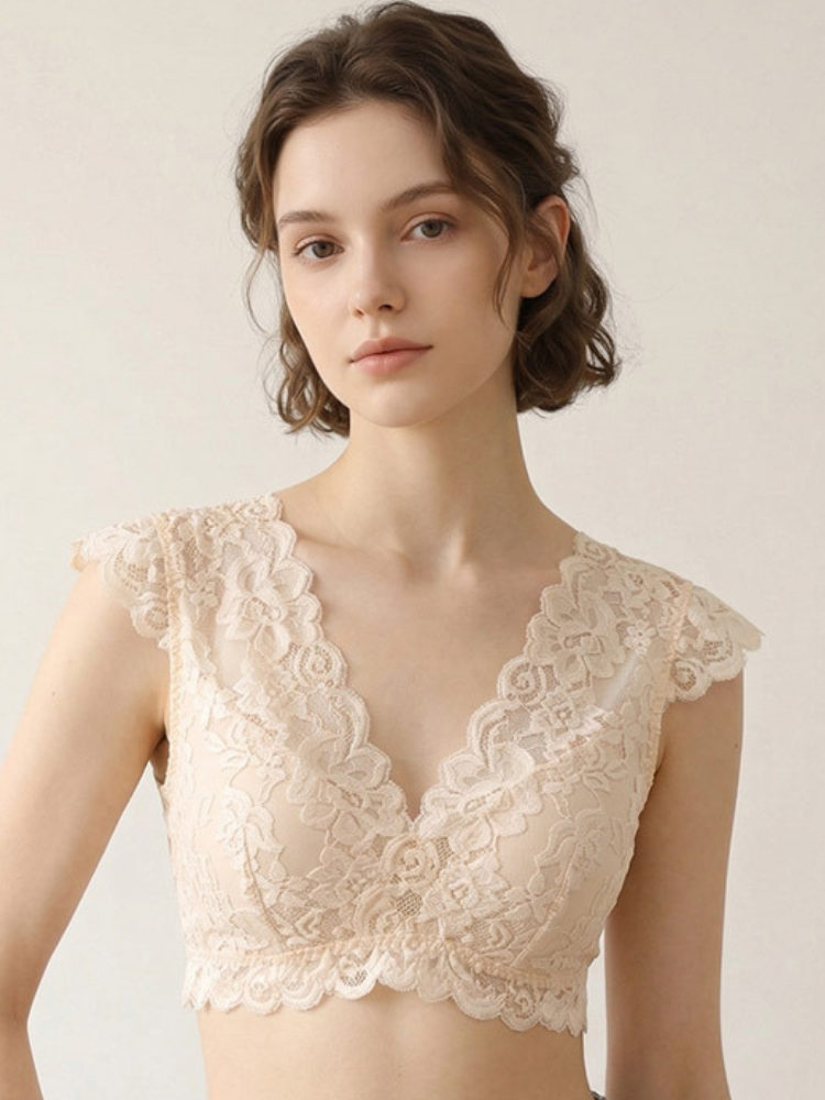 Model wearing a champagne beige lace bra featuring floral lace cap sleeves, a deep V-neckline, and a scalloped hem.