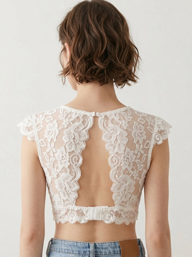 Back view of a model wearing a light-colored floral lace bra, showing the open-back lace design and hook-and-eye closure.