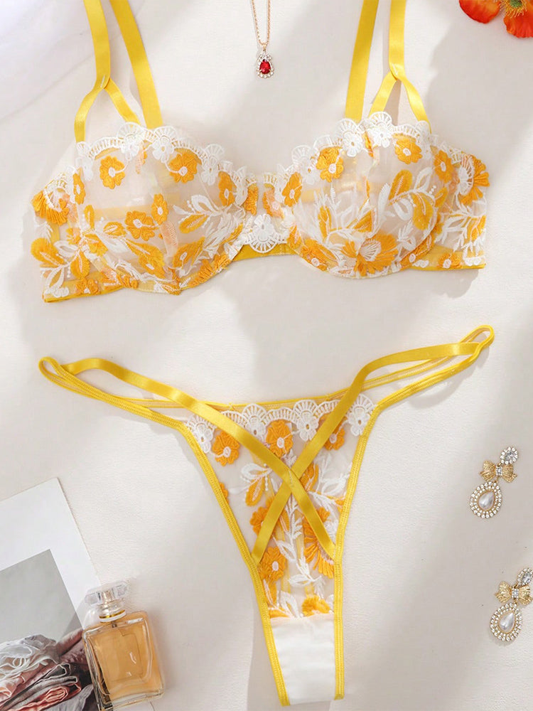 Plus size woman wearing a yellow daisy embroidered underwire bra and matching thong set